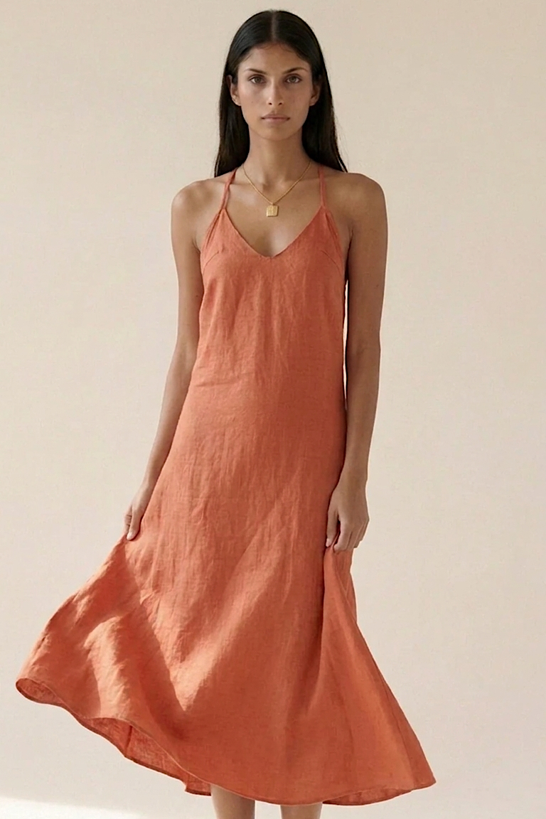 Woman wearing a terracotta dress against a plain background